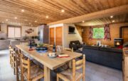 Living room with large dining table , sofas and fire place in chalet Snow Pearl